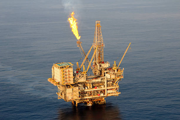 Lone oil rig in middle of sea  Close up aerial photograph of a fixed drilling platform oil rig. Oil Industry in Africa stock pictures, royalty-free photos & images